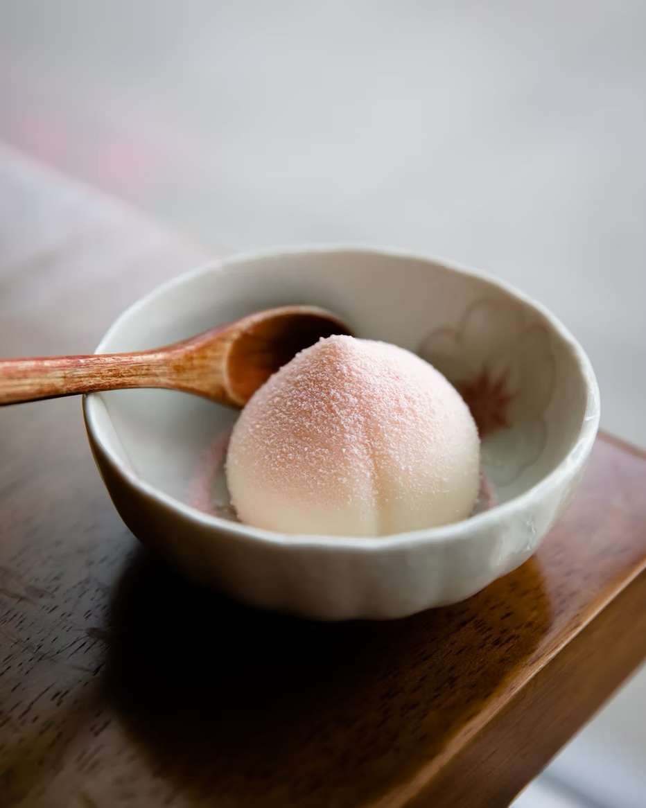 Peach mousse served whole in a ceramic bowl with a wooden spoon