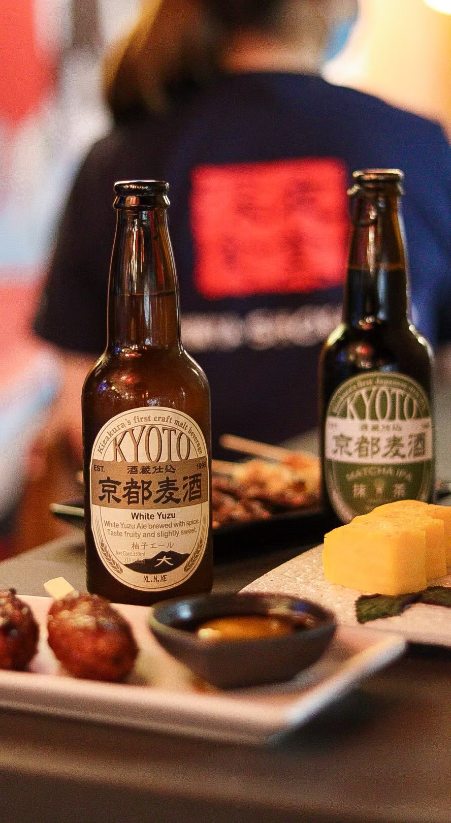 Kyoto craft beer bottles beside takoyaki at the counter